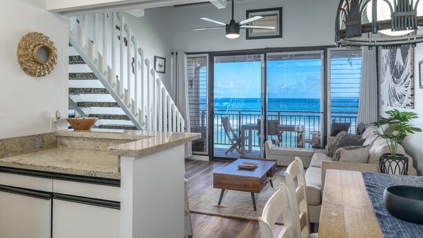 A spacious living area with a large sliding glass door leading to a balcony overlooking the ocean. - Beautiful Beachfront Bungalow (Lahaina)