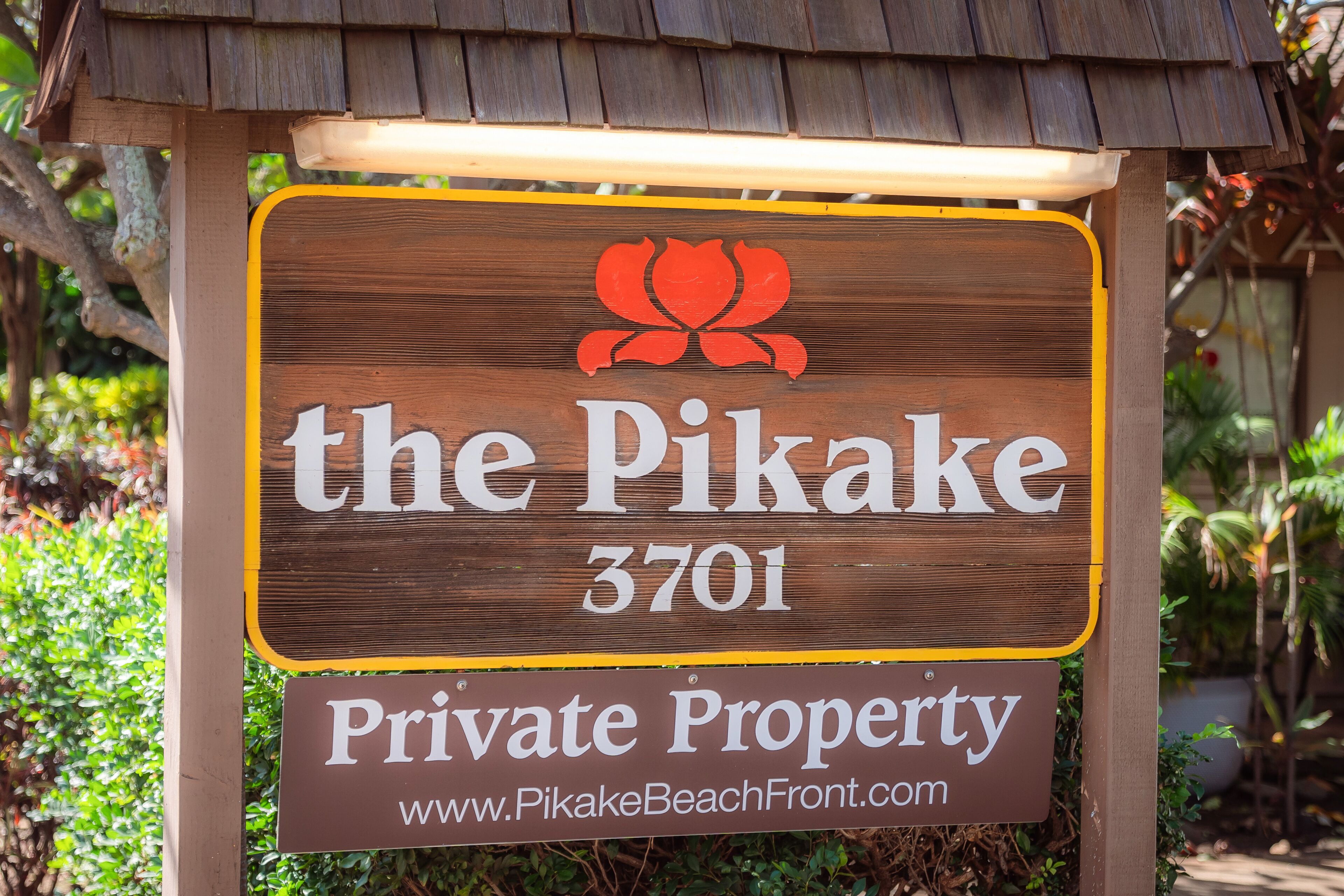 A wooden sign with 'the Pikake 3701' and 'Private Property' written on it.