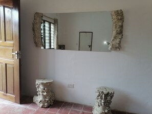 Experience the perfect blend of traditional and contemporary styles in this stylish room, featuring a unique mirror, sculptural stools, and a statement floor.