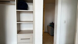 Ein Zimmer mit Kleiderschrank, einer Couch und einem kleinen Tisch.