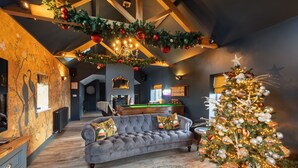 A cozy living room with a grey sofa, a Christmas tree, and a pool table. - May Cottage Titchwell, Norfolk (Titchwell)