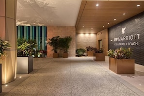 A JW Marriott entrance with a modern design, including a stone wall and potted plants.