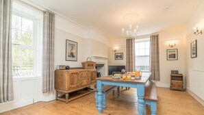 A dining area with a wooden table, chairs, a fireplace, and a television. - Rheithordy -  a self catering cottage that sleeps 9 guests in 5 bedrooms (Blaenau Ffestiniog)