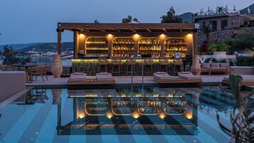 Un bar en la azotea con piscina, zona de bar y asientos.