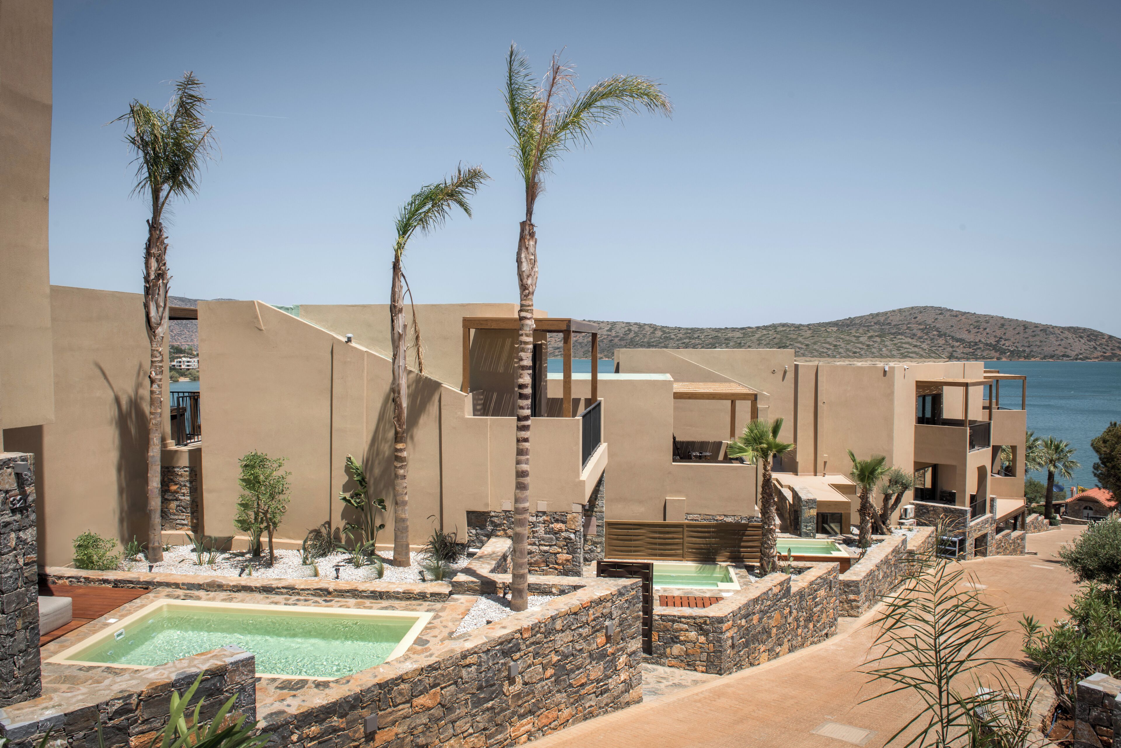 A resort with multiple buildings, outdoor pools, and palm trees.