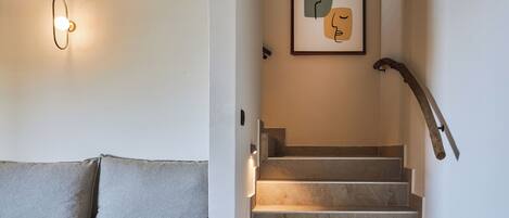 A staircase with a handrail and a wall-mounted light fixture.
