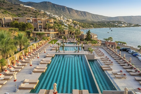 Una piscina al aire libre de temporada, sombrillas. Enorme Infinity Elounda - Adults Only