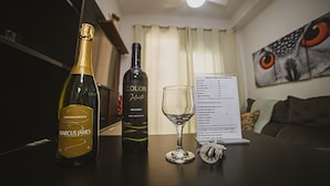A table with two bottles of wine, a wine glass, and a menu. - Chácara Santo Antonio - Laguna 430 (São Paulo)