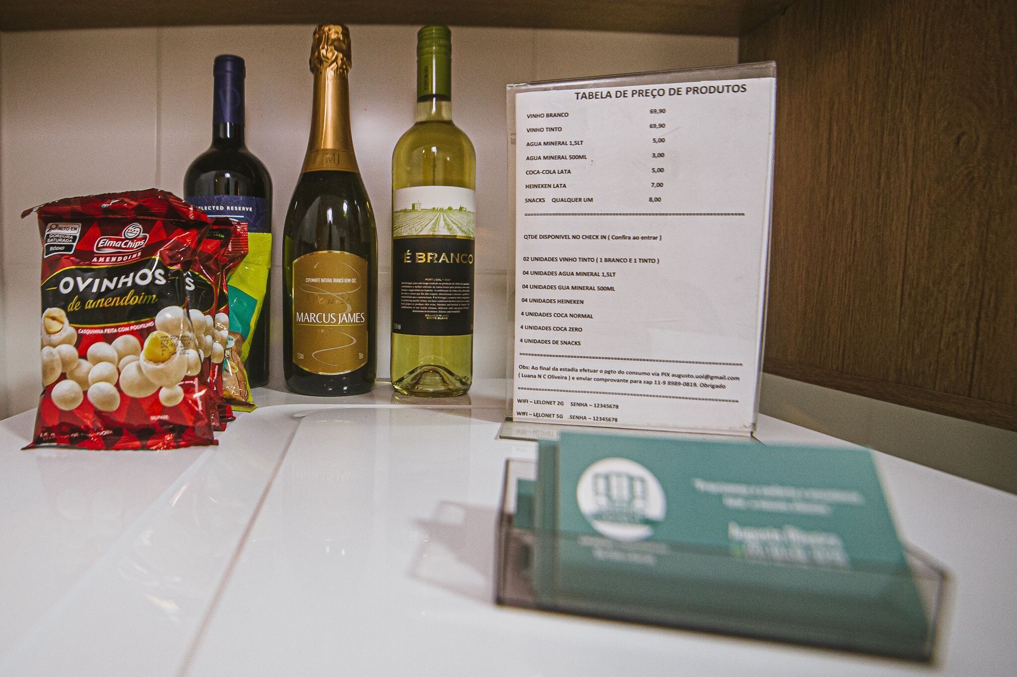 Una mesa con una lista de precios de productos, incluyendo vino, agua mineral y aperitivos.