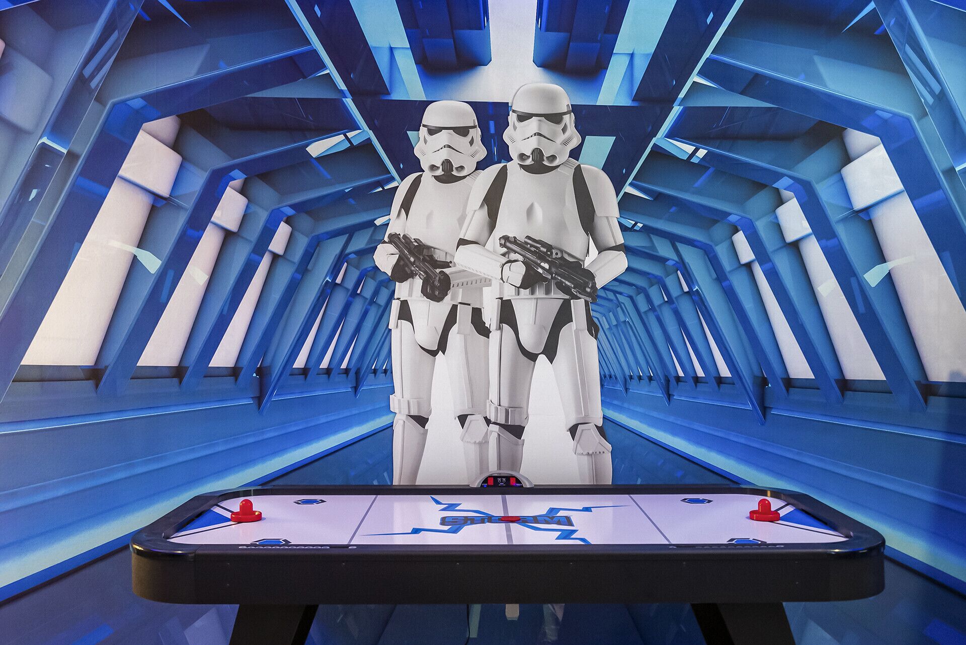 Two stormtroopers standing in a futuristic corridor with a foosball table in the foreground.