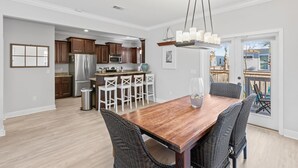 Een moderne keuken met donkere houten kastjes, roestvrijstalen apparatuur en een centraal eiland met barstoelen.