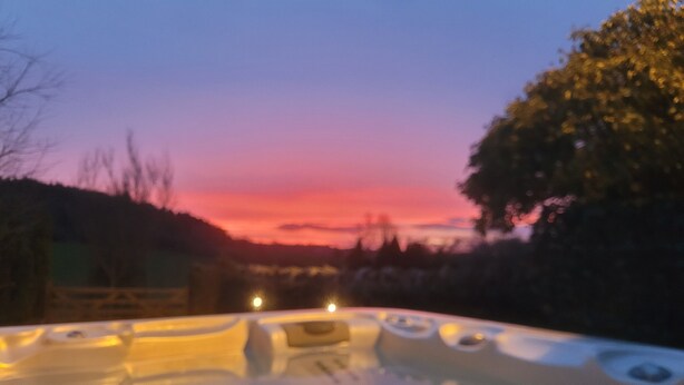 Un jacuzzi con vistas a la puesta de sol.