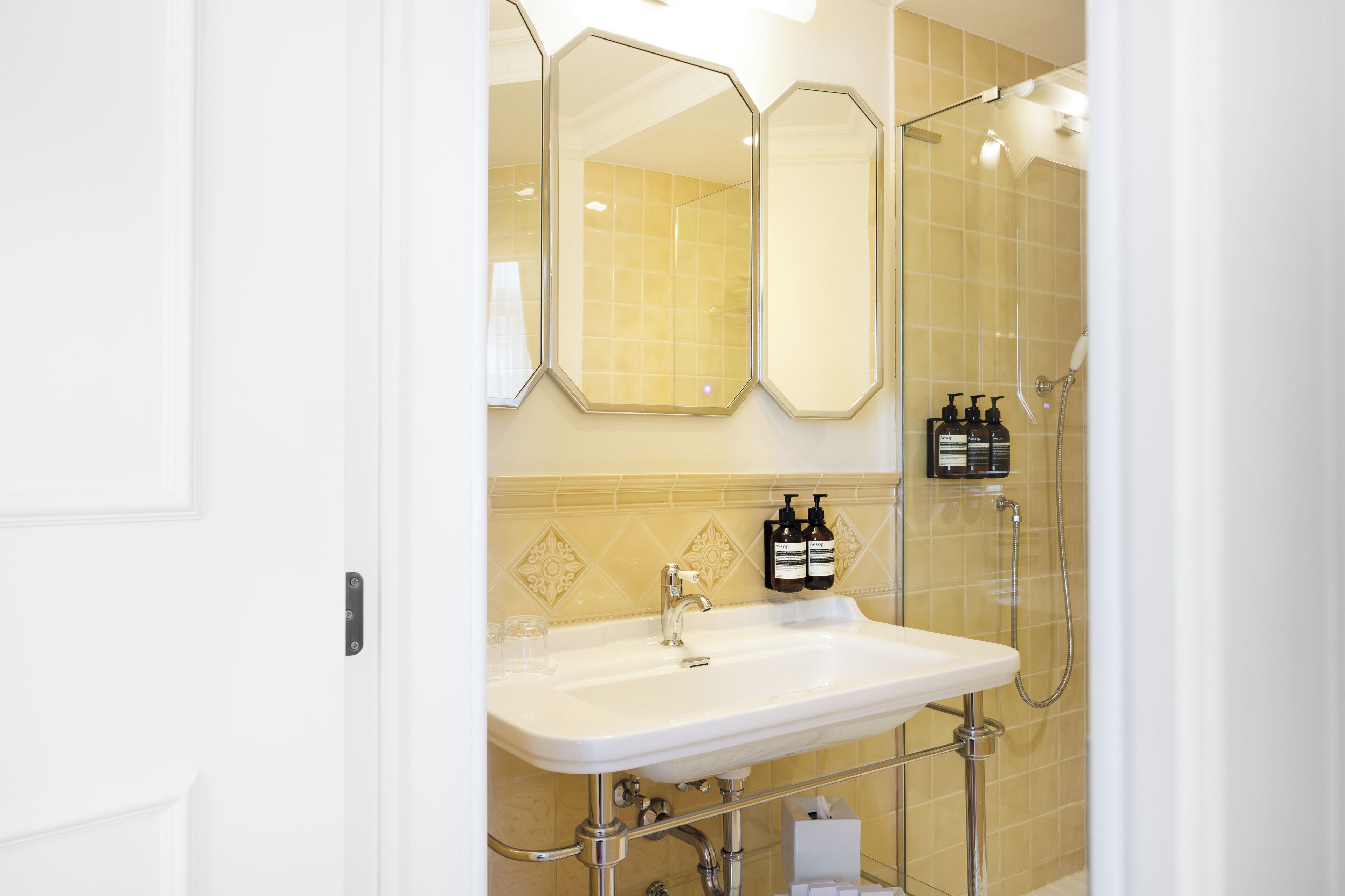 A bathroom with a white sink, a mirror, and a shower.