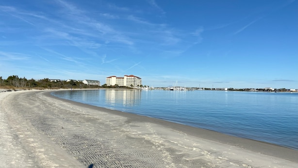 Una playa con un edificio grande al fondo.