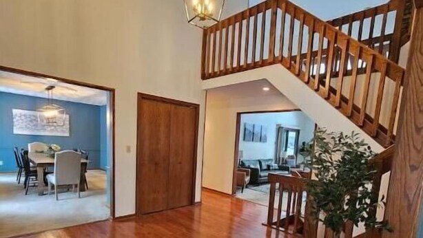 Amplia sala de estar con una escalera de madera, un comedor y vistas a otra habitación.