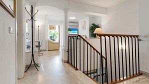 A modern interior with a staircase, a coat rack, and a television in the background. - Duplex in Puerto Banus by Costarentals - Ref M40 (Marbella)