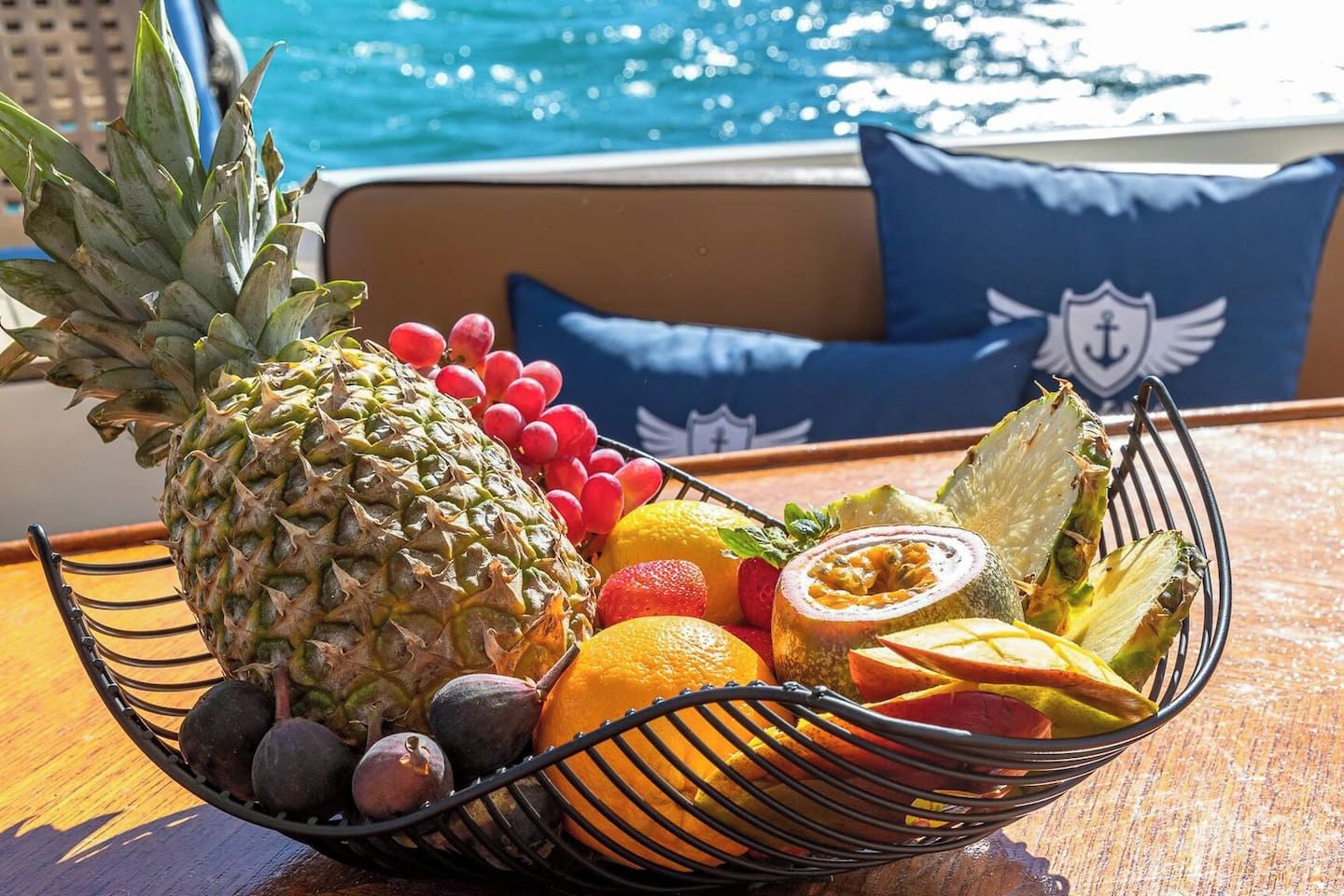 Obstkorb auf einem Tisch am Pool mit Blick auf das Wasser.