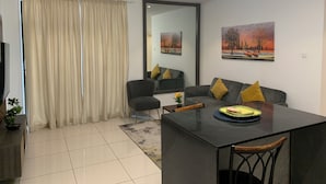 A modern living room with a dining area, featuring a sofa, chairs, a coffee table, and artwork on the walls. -  Embassy Gardens by Morninglife Luxury (Accra)