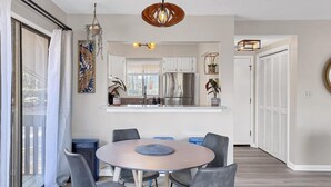 A modern kitchen with white cabinets, a stainless steel refrigerator, and a hanging light fixture. - Pinehurst 2-bedroom, 2-bath Condo Available for Rent (Pinehurst)