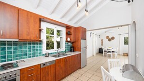 Een moderne keuken met houten kastjes, een roestvrijstalen spoelbak en een inbouwoven.