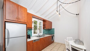 A kitchen with wooden cabinets, a white refrigerator, a sink, and a stove.