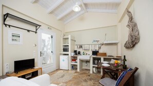 Un espace de vie compact comprenant un coin cuisine, un coin repas et un coin salon avec un téléviseur et un canapé.