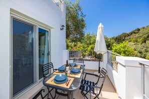 Enjoy al fresco dining in a serene outdoor setting with a table for four, complete with fine china and wine.