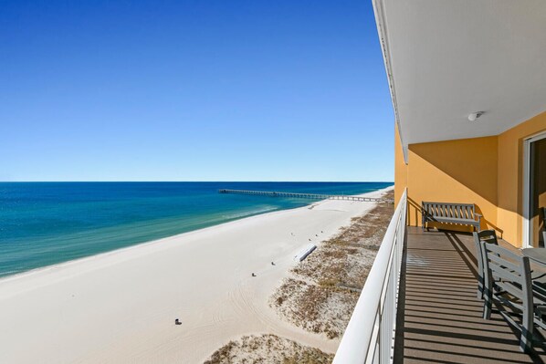 Un balcón con vista a una playa y un muelle.