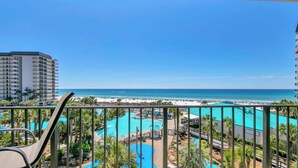 Ein Balkon mit Blick auf einen Resort-Pool und den Strand.