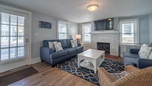 A living room with a fireplace, a sofa, a coffee table, and a television.