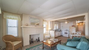 Una sala de estar con chimenea, un comedor y una cocina.