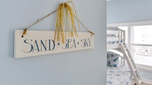 A sign with the words "SAND SEA SKY" hanging on a wall. - OCHG Oceanfront Villa 2 (Ocean City)