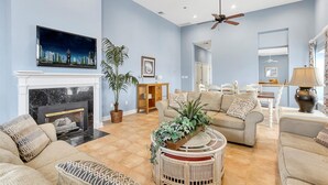 A spacious living room with a fireplace, comfortable seating, and a ceiling fan. - OCHG Oceanfront Villa 2 (Ocean City)