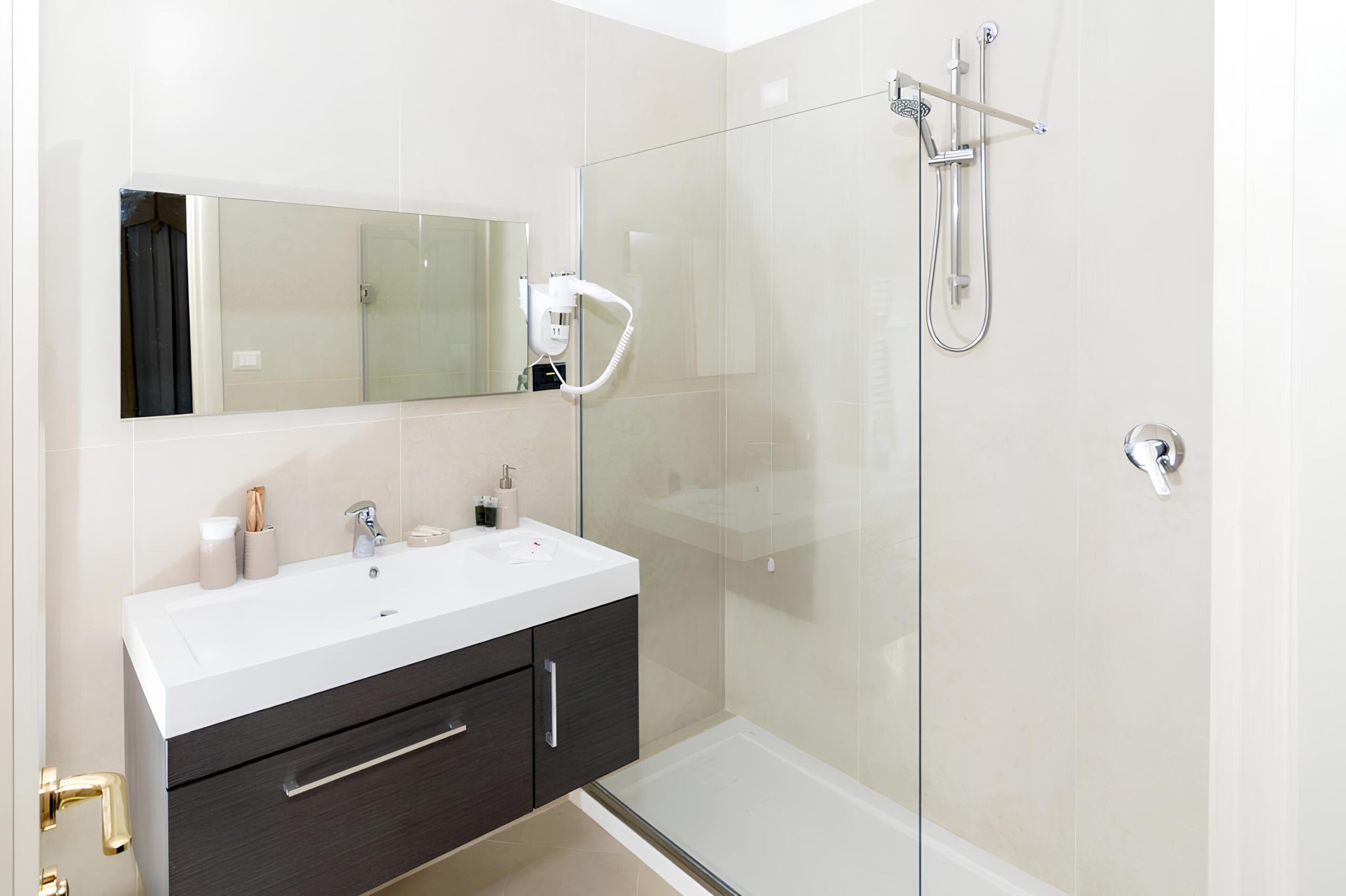 A modern bathroom with a glass shower enclosure, a vanity with a mirror, and a sink.