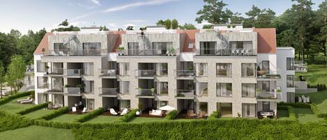 A modern multi-story residential building with balconies, large windows, and a well-maintained garden.