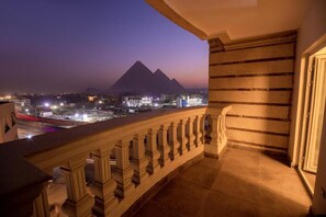 A balcony with a view of pyramids at dusk. - Blue Pyramids Eyes Hotel (Giza)