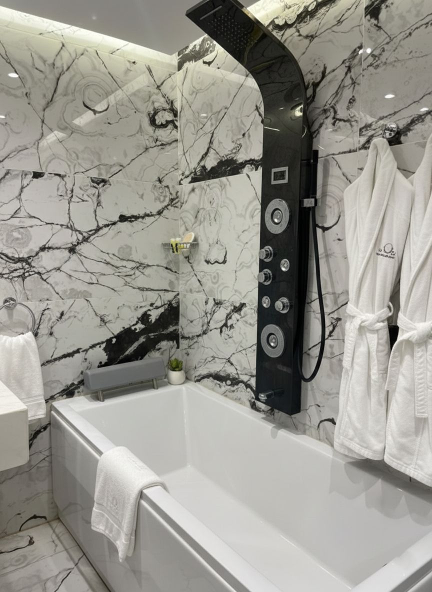 Ein modernes Badezimmer mit Marmorwand, einer großen Badewanne, einem schwarzen Duschkopf und weißen Handtüchern.