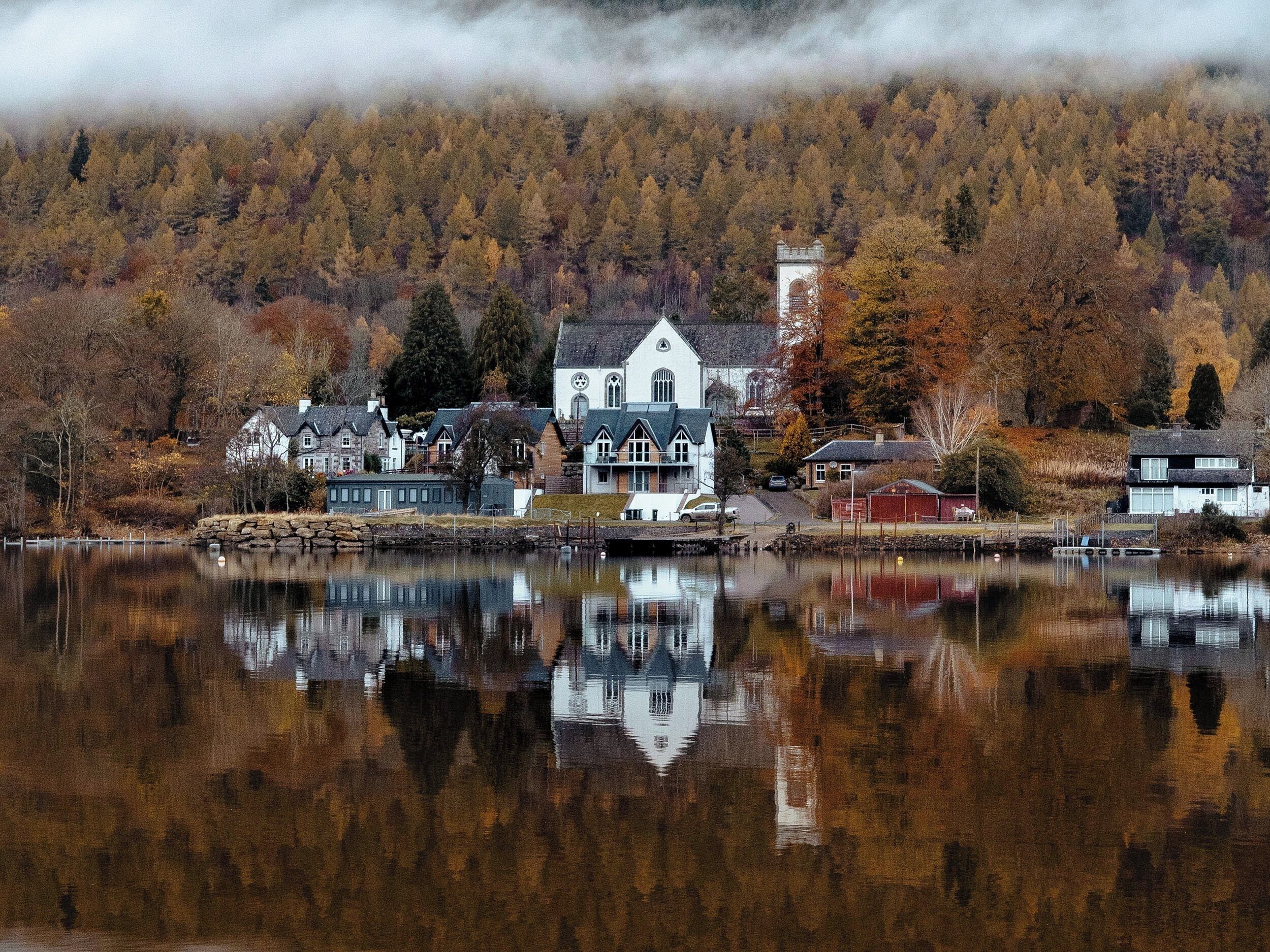 A lakeside village with a prominent white church and residential buildings.