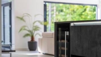Un interior moderno con un ventanal grande, una planta en maceta y un diseño minimalista.