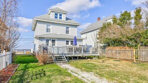 A two-story house with a covered deck and a fenced yard.
