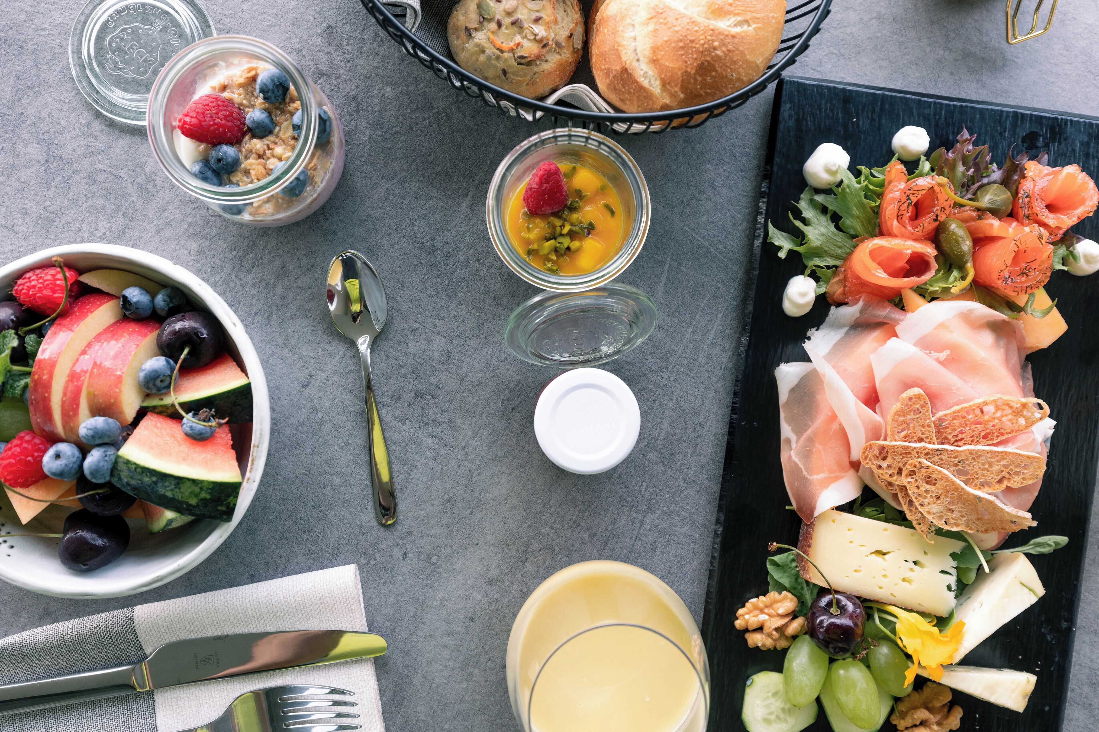 A variety of food items including fruits, cheeses, and bread on a table.