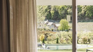 Une chambre avec une grande fenêtre donnant sur un jardin et une piscine.
