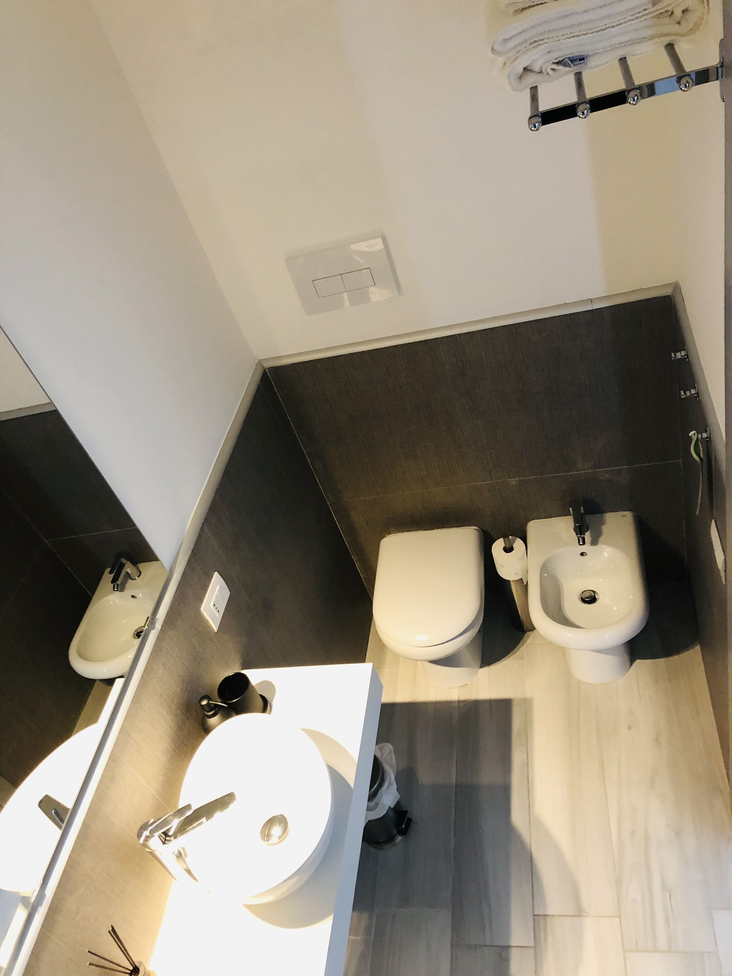 Ein modernes Badezimmer mit einer Bidet-Funktion, Toilette und Waschbecken.