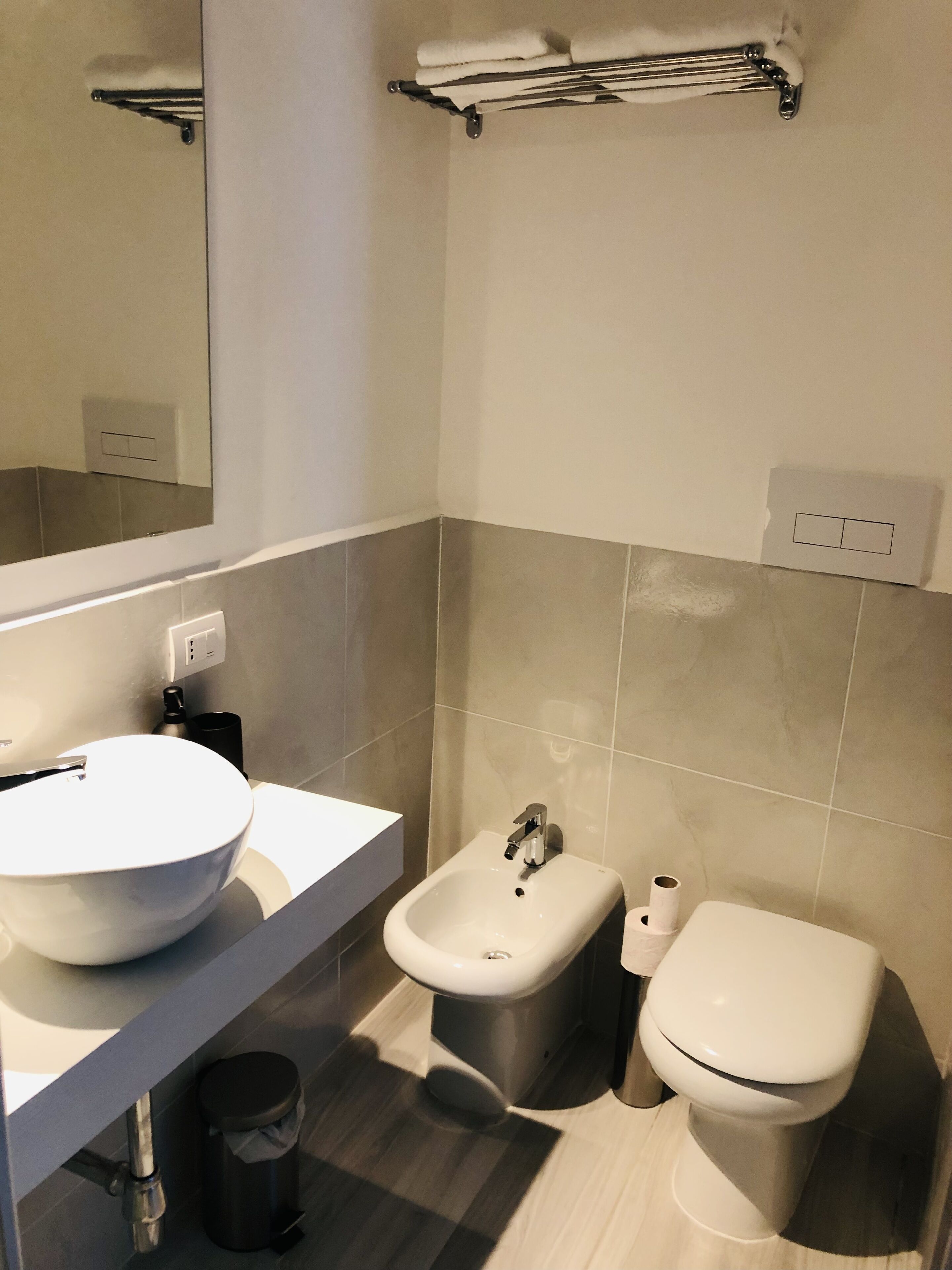 Ein modernes Badezimmer mit Waschbecken, Bidet und Toilette in Weiß.