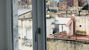 Finestra amb vista a un paisatge urbà, incloent edificis i un cel serè.