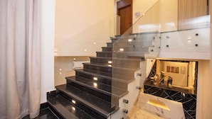 Eine moderne Treppe mit Glastrennwand und einer Marmor-Podestfläche.