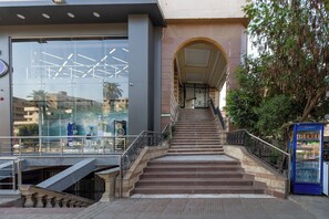 A staircase leading to a building entrance with a glass facade and a Pepsi vending machine.
