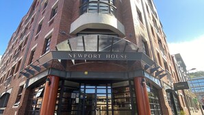 A multi-story building with a prominent entrance labeled "NEWPORT HOUSE." - Artistic Spacious Luxury Loft, a 10 min. walk to V&A Waterfront & fine dining! (Cape Town)