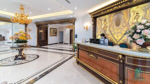 A reception area with a marble floor, a reception desk labeled "VICTORIA," and a large decorative painting on the wall. - Victoria Apartment Paradise Suites (Hanoi)