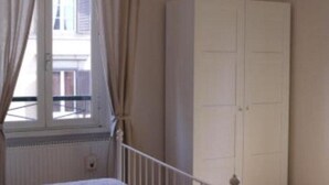 Une pièce avec une fenêtre, une armoire blanche et une balustrade blanche.